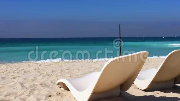沙滩上的白色躺椅和浪花视频的预览图