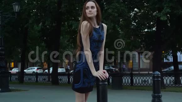 一位身穿蓝色连衣裙的年轻美女独自站在城市里视频的预览图