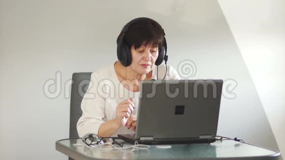 带麦克风的女士通过电脑与顾客交谈妇女与个人电脑通过Skype沟通妇女视频的预览图