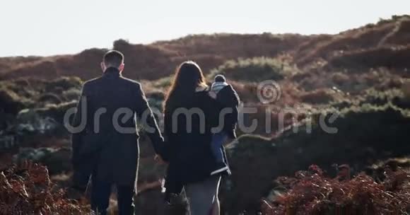 快乐的年轻家庭一起享受自然户外日落4k用红色电影摄影机拍摄视频的预览图