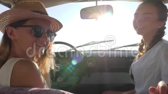 汽车旅行和我们一起在汽车上两个女孩在阳光下汽车女性在背景下慢慢进入汽车视频的预览图