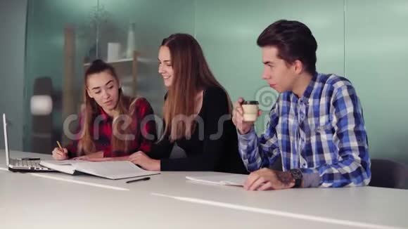 一群年轻人在现代公寓开会三个正在做作业的学生坐在一起视频的预览图