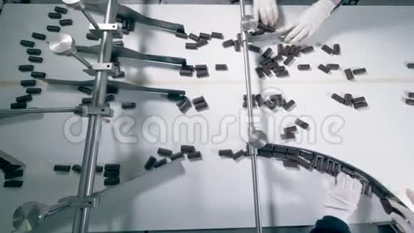 巧克力糖果沿着传送带向三个不同方向移动的俯视图视频的预览图