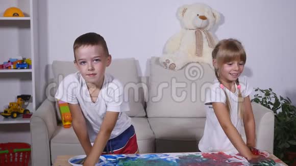 女孩和男孩在油漆中举手视频的预览图