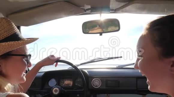 年轻女性到前座汽车展手到远方的地平线快乐的旅程可爱的女朋友在海岸视频的预览图