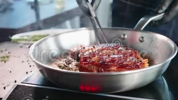 厨师用钳子把炸好的多汁肉排放在煎锅里翻特写视频的预览图