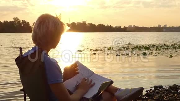 在斯隆莫的河岸上人在思考把一些东西写在记事本上视频的预览图