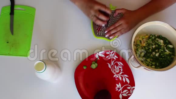 一个女人正在把煮好的甜菜切在蔬菜磨盘上锅旁边是蔬菜汤的其他原料视频的预览图