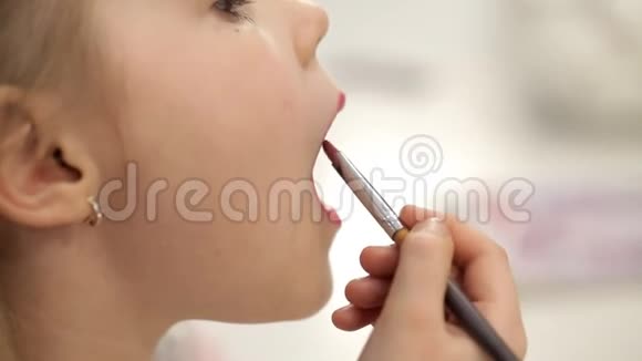 小姑娘姑娘用口红涂嘴唇视频的预览图