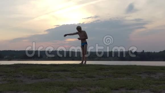 年轻人在懒洋洋的湖岸上挥动双手视频的预览图