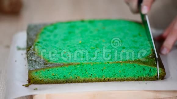 女用手拿刀切绿色海绵蛋糕视频的预览图
