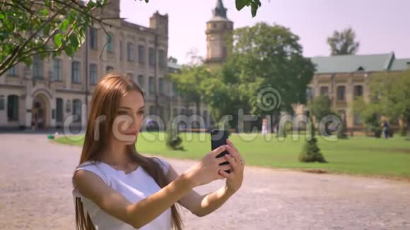 女孩在夏天白天在公园的智能手机上自拍交流理念视频的预览图