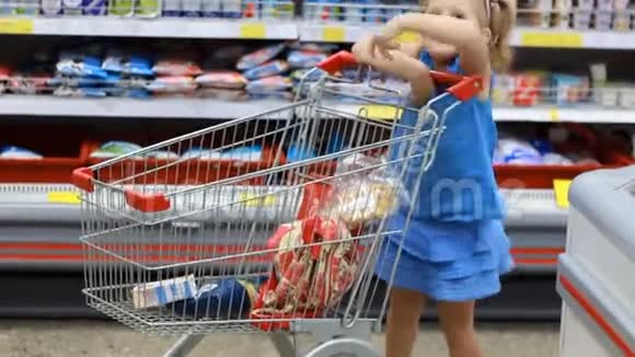 超市里的小女孩用手推车买食物作为产品孩子购物视频的预览图