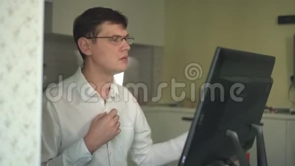 一个男人在紧张的家庭办公室里解开白色衬衫上的纽扣视频的预览图