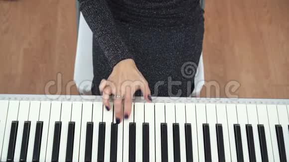 女钢琴家手用单手弹钢琴的俯视图视频的预览图