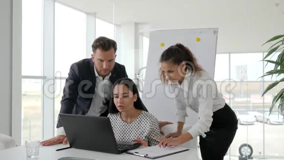 愉快地拥抱办公场所的合作者在笔记本电脑上成功的商业交易快乐的商业伙伴视频的预览图