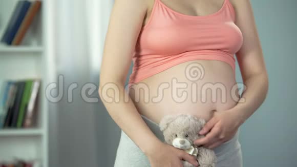 怀胎抱玩具熊的梦中女人代孕妈妈视频的预览图