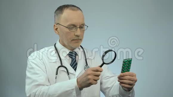 医生用放大镜看一包药丸假药视频的预览图