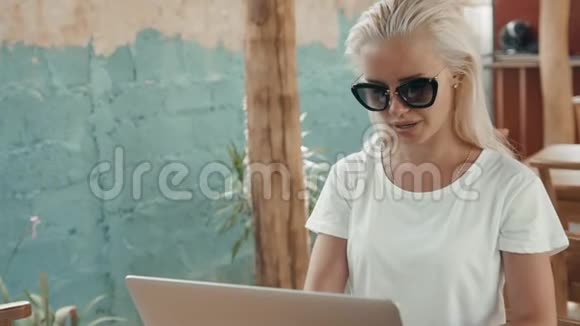 年轻成功的自由职业者女性喜欢在暑假期间在便携式电脑上工作金发美女视频的预览图