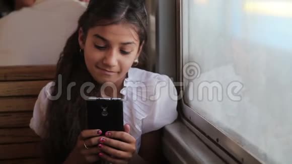一个在火车上用智能手机的小吉普赛女孩视频的预览图