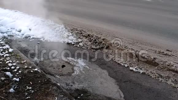 蒸汽来自路边雪中的卫生下水道盖侧视视频的预览图