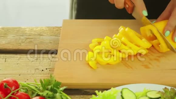 一个女人手里拿着一把刀把黄椒切成沙拉片视频的预览图