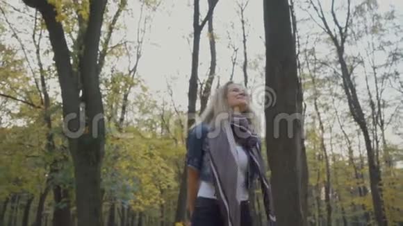 秋天公园里女人带着一束秋叶散步视频的预览图