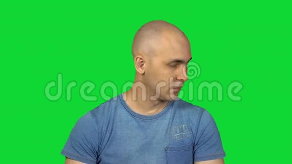 戴着绿色背景梳子的秃头男人视频的预览图