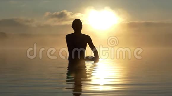 日落时分人类缓缓地从水面上抬起双手视频的预览图
