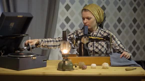 裁缝女孩用旧的手工缝纫机缝制布女裁缝员晚上在家或车间工作视频的预览图