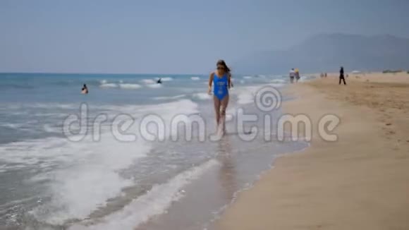 年轻女子在沙滩上奔跑视频的预览图