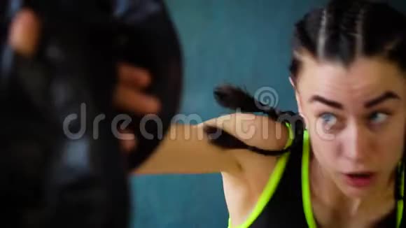 近距离配合白色女拳击手训练与拳击教练在健身房慢动作视频的预览图