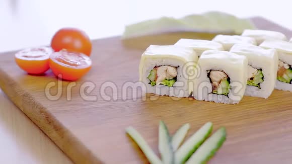 加鸡肉黄瓜青菜和奶油奶酪的卷放在木板上配蔬菜视频的预览图