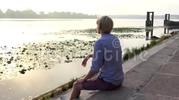 年轻人在夕阳下的狄尼伯河畔沉思默想视频的预览图