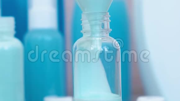将蓝色洗发水倒入一小瓶大的漏斗中旅行的罐子瓶子特写视频的预览图