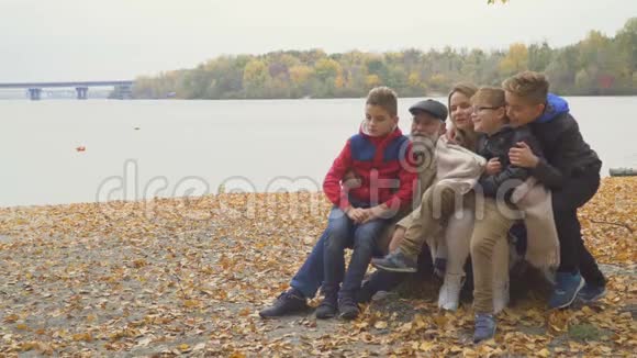 秋天公园有成年女儿和孙子孙女的快乐爷爷视频的预览图