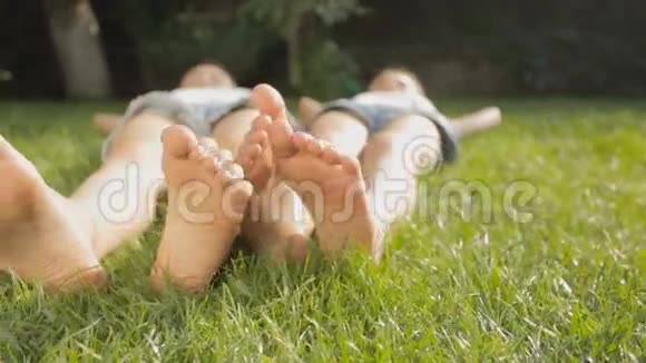 阳光明媚的一天两只女孩的脚在草地上放松视频的预览图