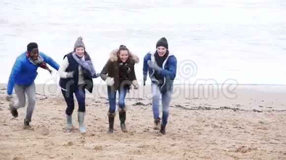 年轻夫妇在冬季海滩上奔跑视频的预览图