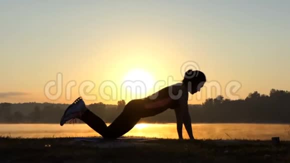 日落时分女人在湖岸打造健身中心视频的预览图