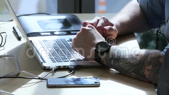 一个有纹身的男人在笔记本电脑上工作视频的预览图