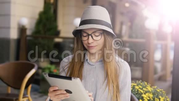 女孩在户外咖啡厅使用平板电脑视频的预览图