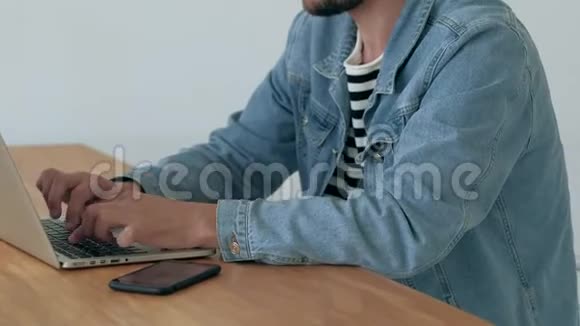 男人在办公室的笔记本电脑上工作视频的预览图