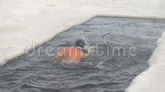 一个戴银帽的人在冰洞里游泳视频的预览图