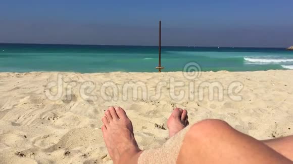 沙滩上的沙滩上的雄脚背景海水蓝色海水视频的预览图