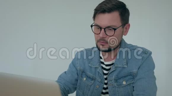 男人在办公室的笔记本电脑上工作视频的预览图