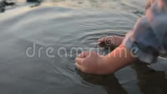 一个小女孩在海边泼海水视频的预览图