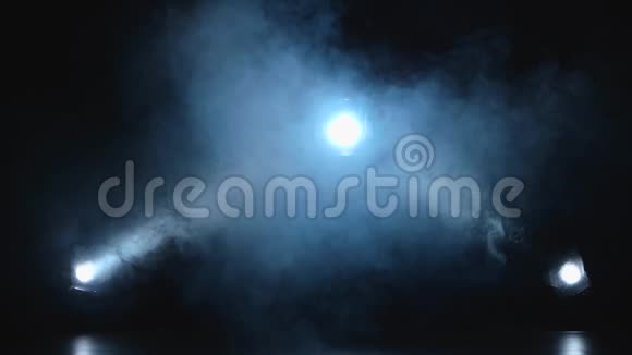 三盏白色聚光灯笼罩在黑色背景的烟雾中视频的预览图