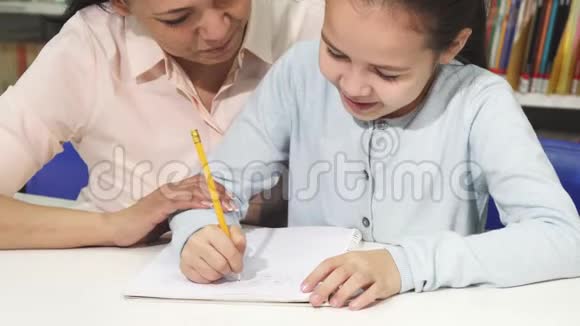 可爱的小女孩和她妈妈一起做作业视频的预览图