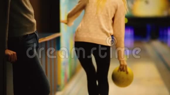 在保龄球比赛俱乐部里运动员投掷一个保龄球击倒滑球女孩把一个球扔在视频的预览图
