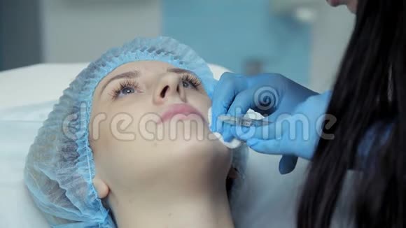 在美容院医生美容师把肉毒杆菌注射到女孩嘴唇上隆唇过程视频的预览图